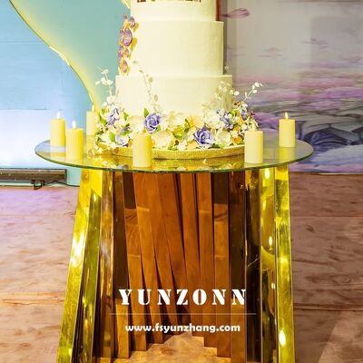 अच्छा दाम होटल फर्नीचर के लिए गोल सोने के घोंसले के आधार के साथ सफेद ग्लास वेडिंग डिस्प्ले केक टेबल स्टेनलेस स्टील ऑनलाइन